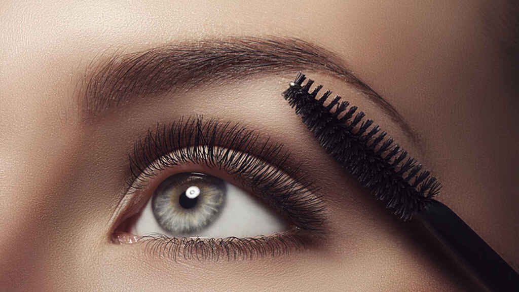 mujer arreglandose las cejas